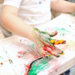 Boy painting with finger-paints