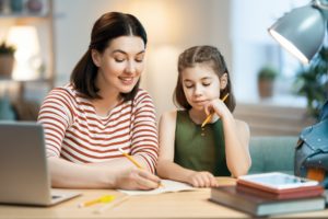 Girl doing homework with mother