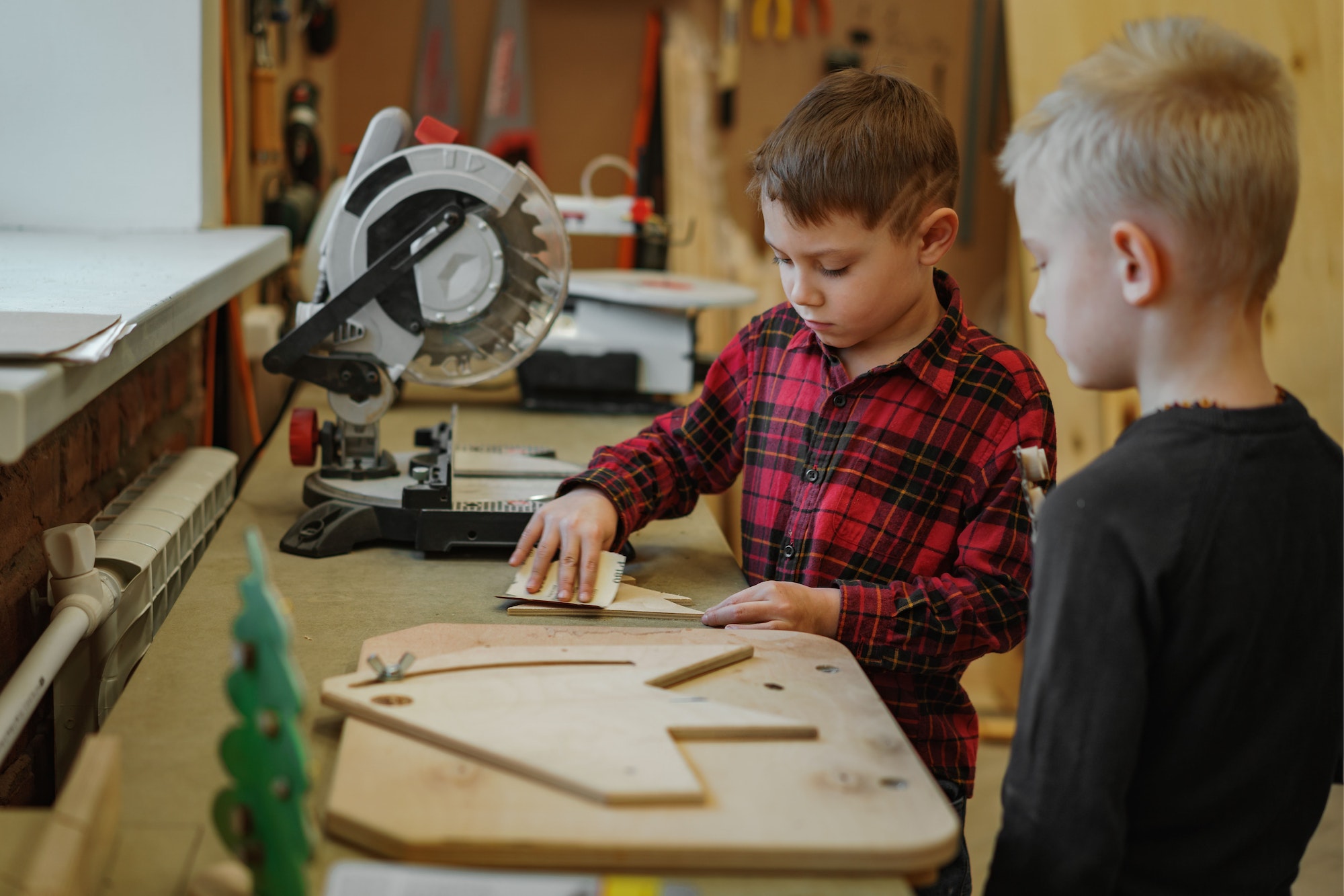 Boys work in a joinery workshop making craft of wood