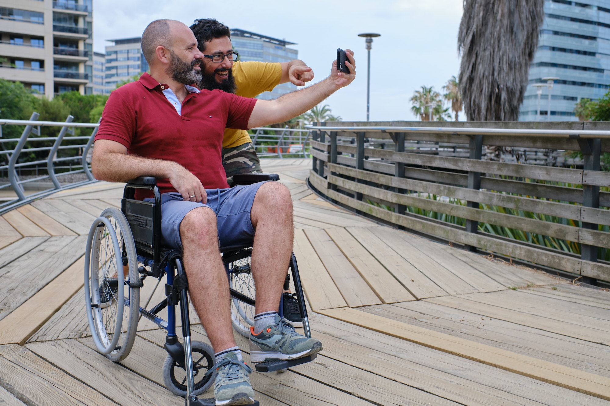 Carer Pushing Senior Man In Wheelchair - people with disabilites concept