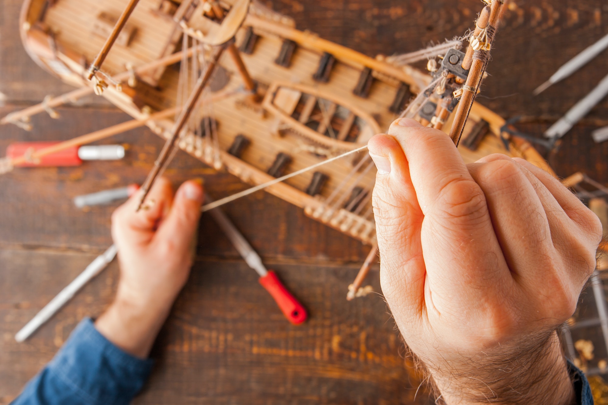 Man collects the vehicle model on the wooden table