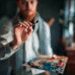 Painter with brush in hand selective focus