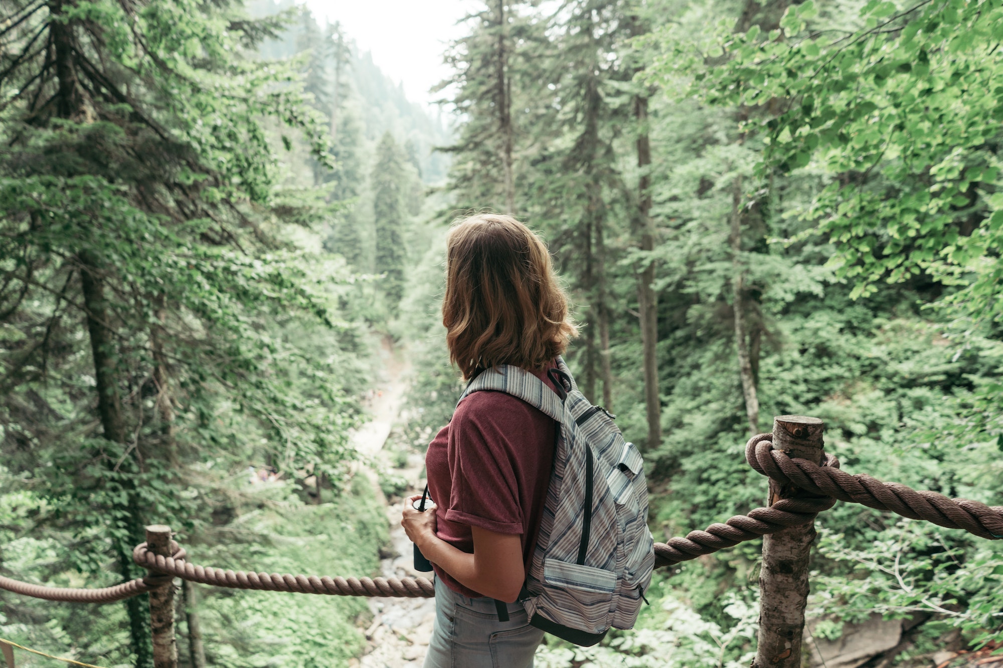 Rear view of a woman with a backpack in the mountains in a nature reserve.