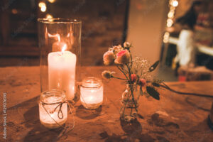 Windlichter und Blumenschmuck auf rustikalem Holztisch